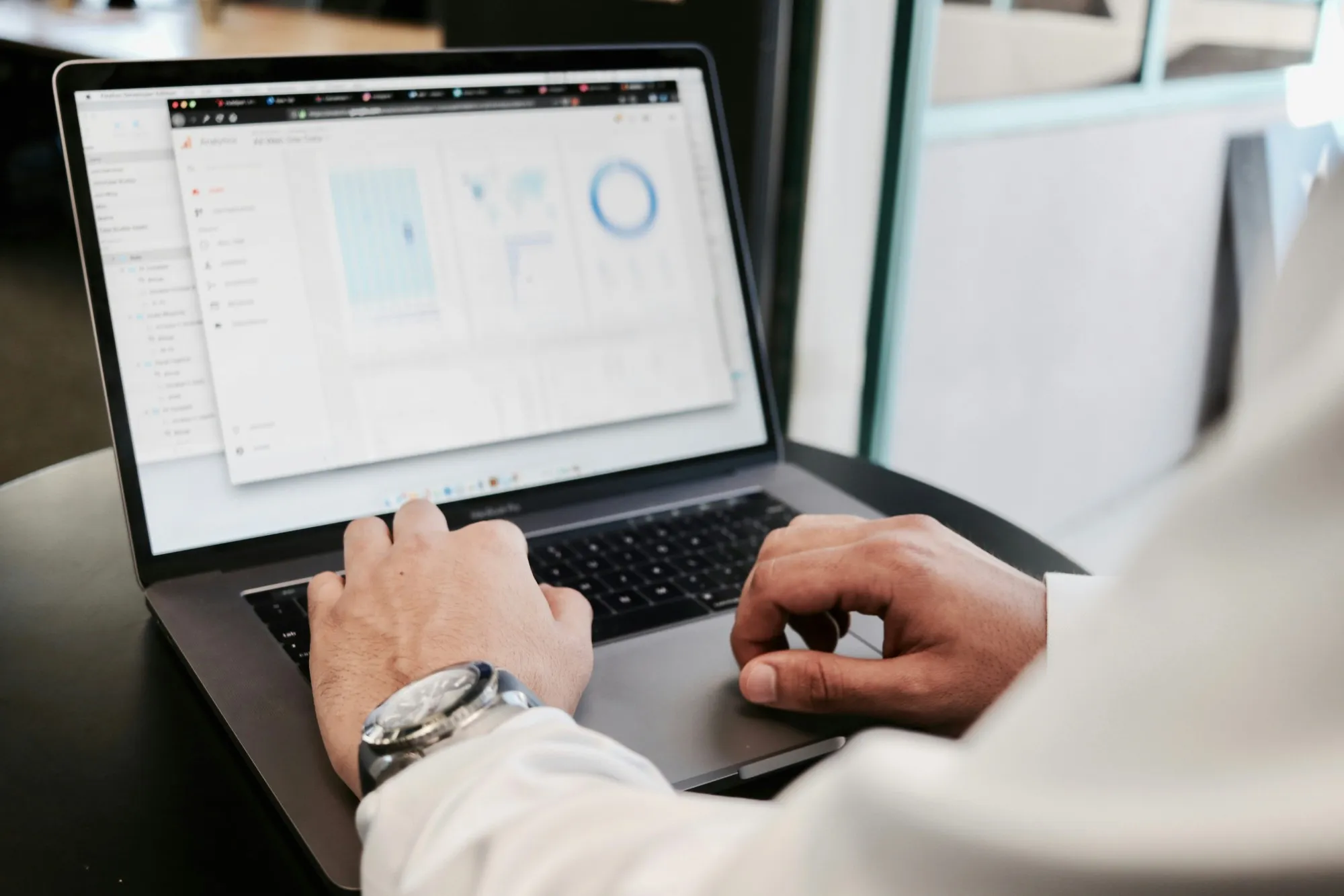 Hände auf der Tastatur eines Laptops mit geöffneter Software
